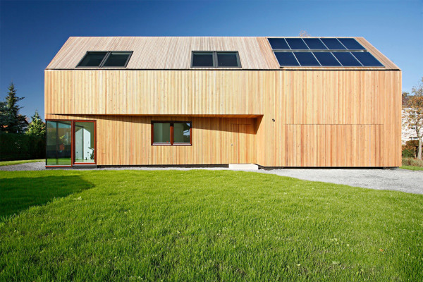 Aussenansicht des Niedrigenergiehauses mit Lärchenholzverkleidung der Fassade und Sonnenkollektoren auf dem Dach.