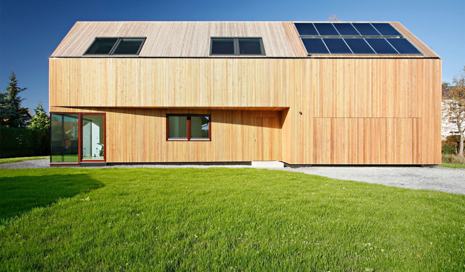 Aussenansicht des Niedrigenergiehauses mit Lärchenholzverkleidung der Fassade und Sonnenkollektoren auf dem Dach.